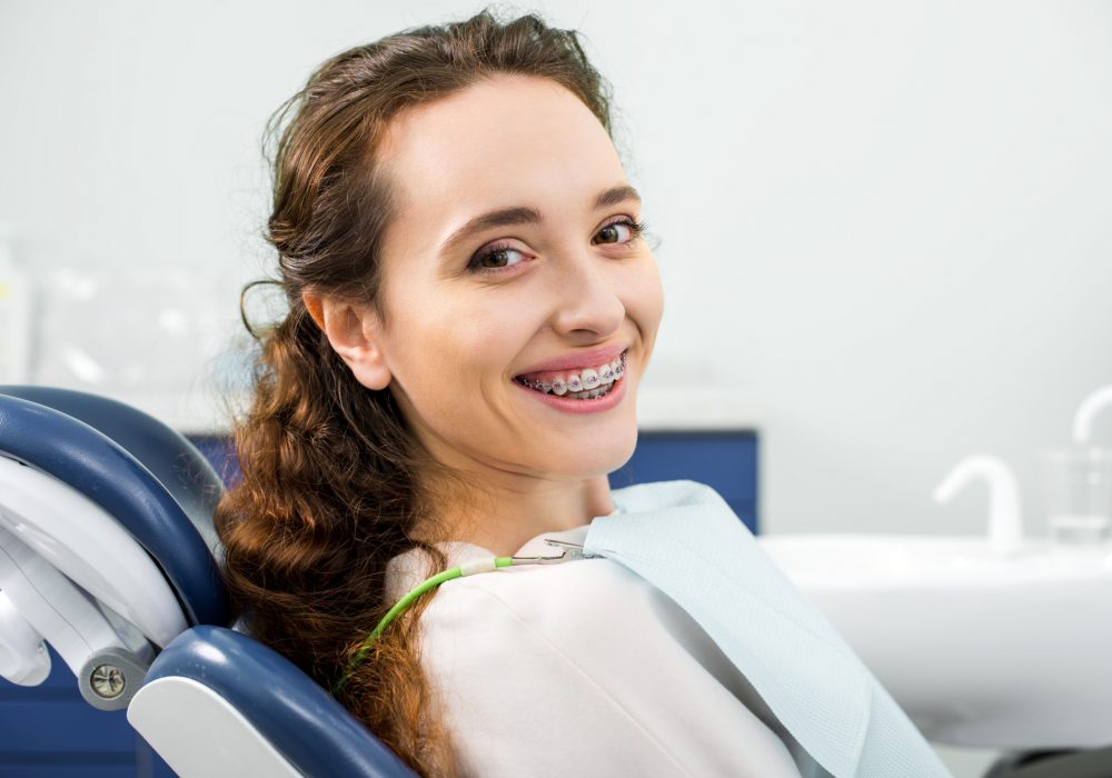 happy woman in braces smiling during examination in dental clinic